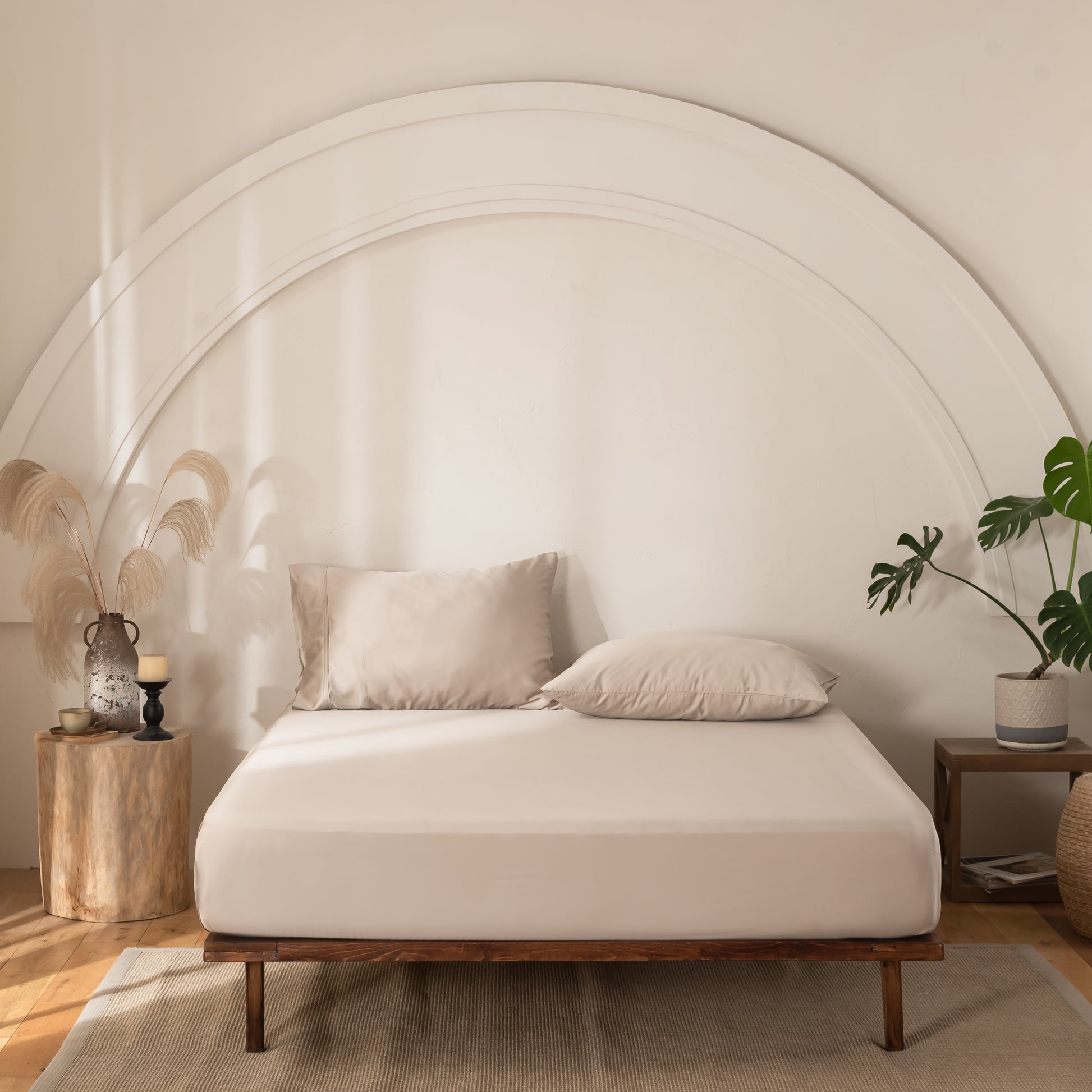 Neatly made bed with beige bedding in a modern bedroom setting.