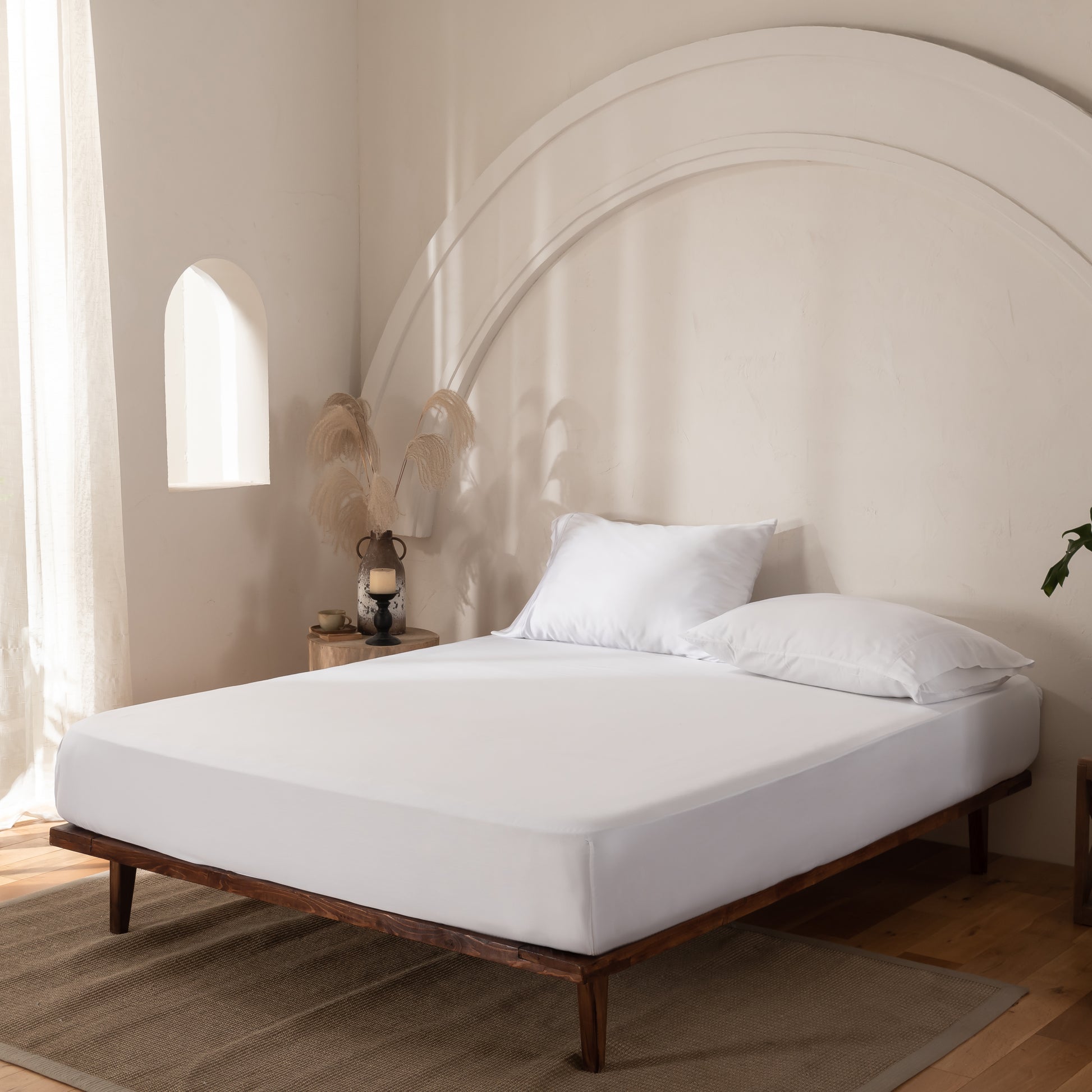 Bed with white mattress and pillows in a bedroom setting